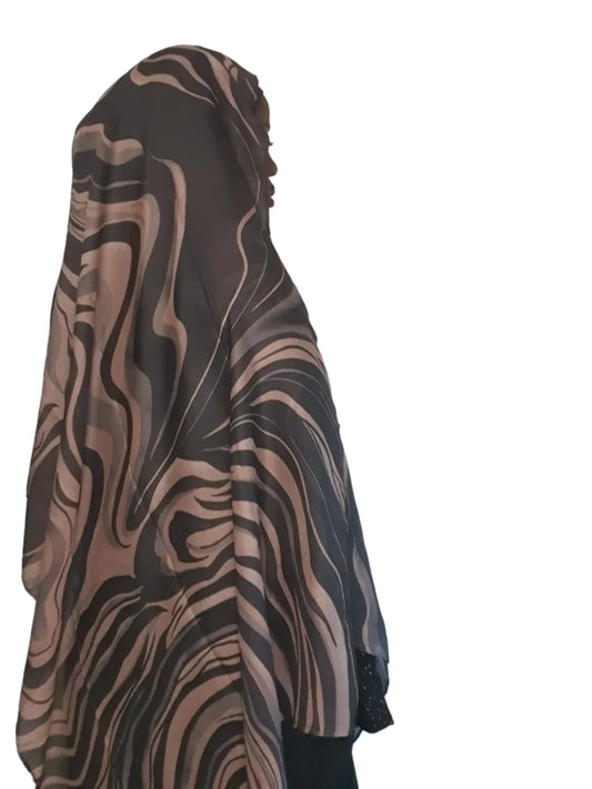 Model wearing a mocha and taupe cotton modal hijab with abstract wave print, shown from side angle for drape and length.