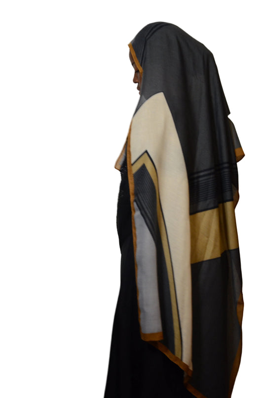 Black, white, and gold jacket on a mannequin against a plain background