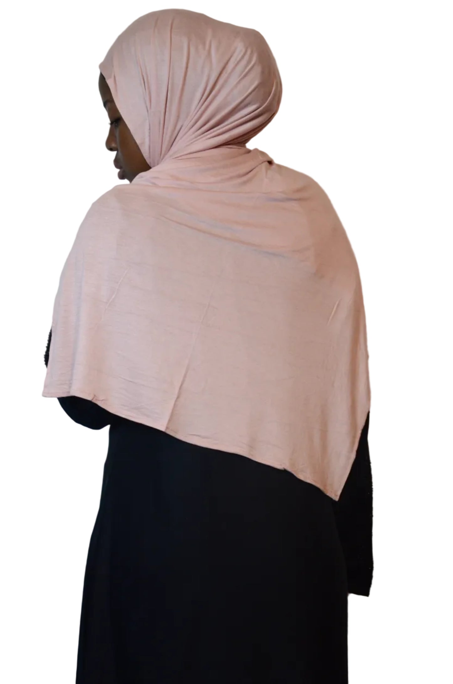 Model wearing a blush pink plain jersey hijab styled at the back over a black abaya