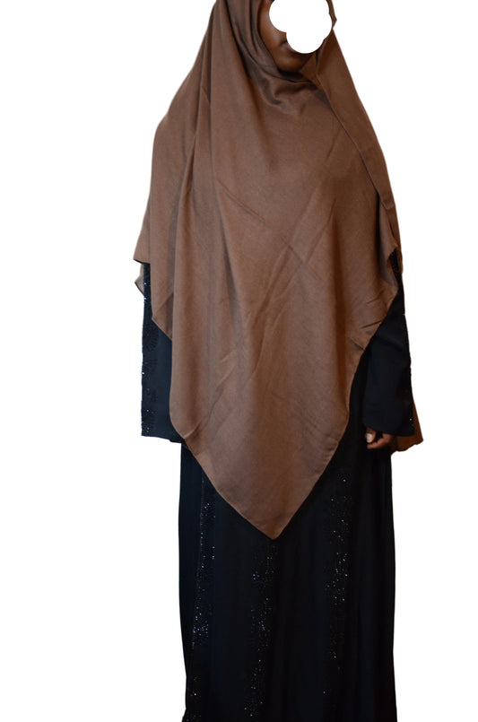Model wearing a chocolate brown plain cotton linen hijab styled in a front drape over a black abaya.