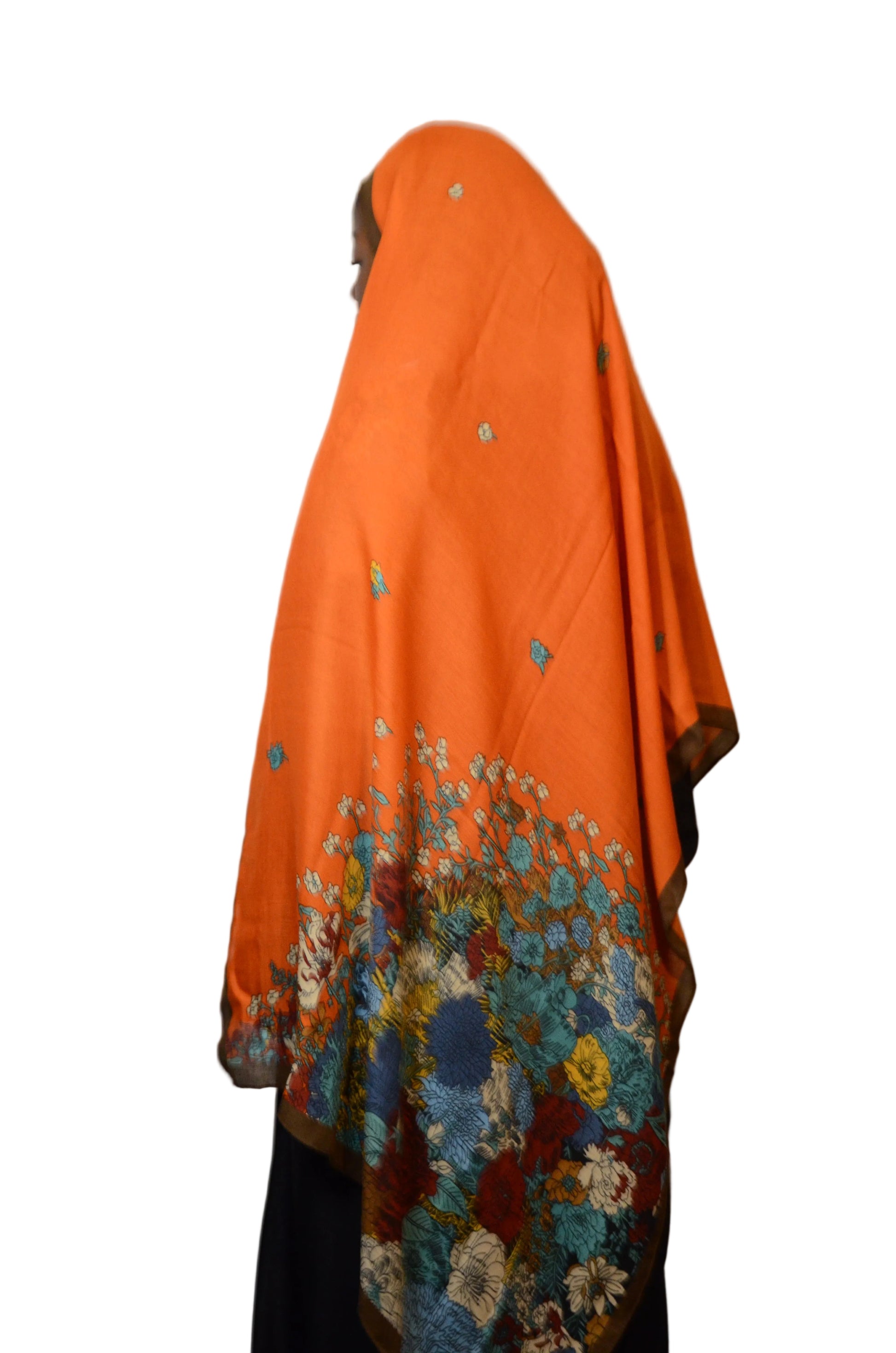 Model wearing a burnt orange floral cotton voile linen hijab, featuring a vibrant botanical print and lightweight drape.