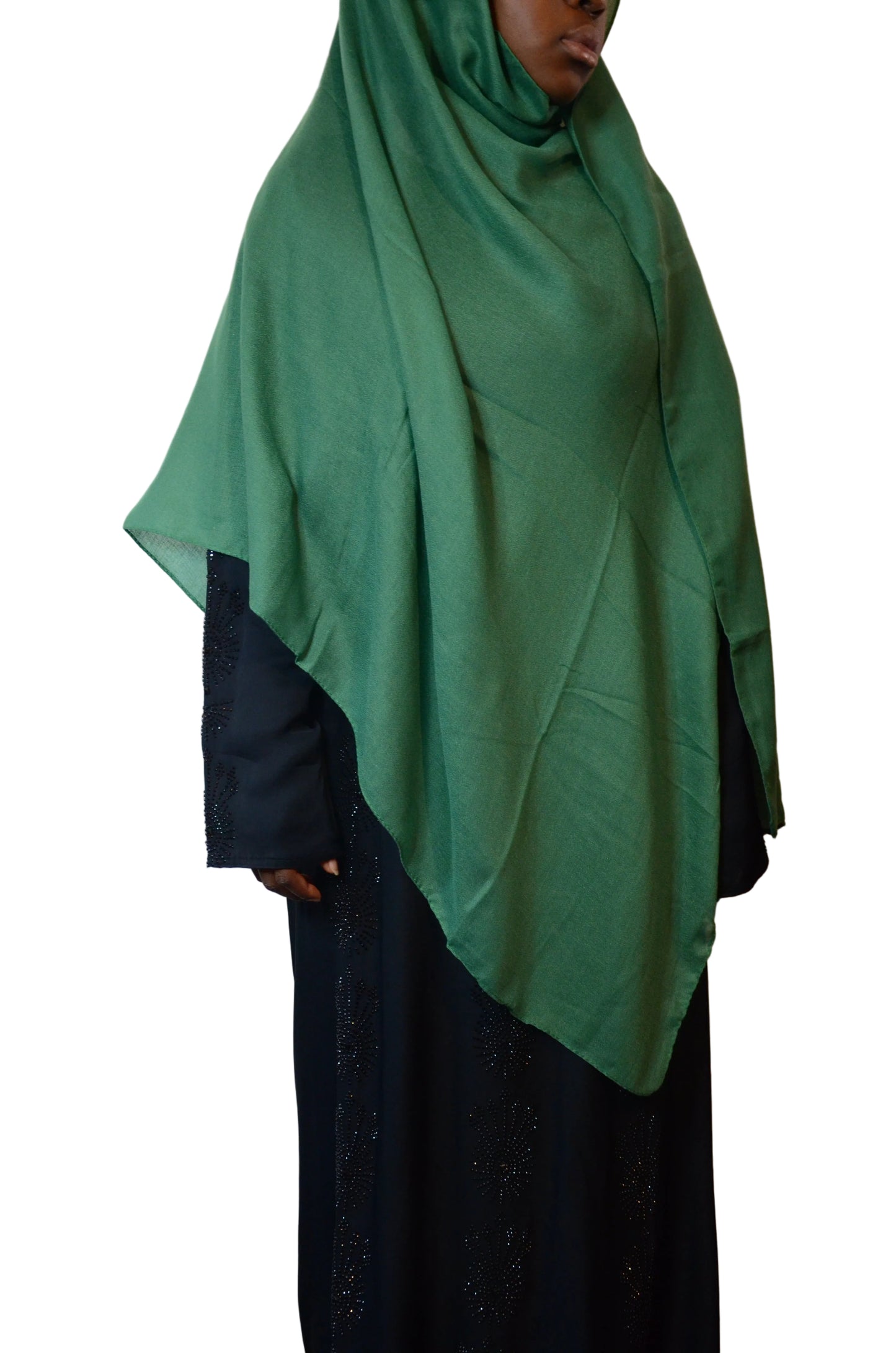 Model wearing a forest green plain cotton linen hijab styled loosely over a black abaya, showing a soft drape and lightweight finish.