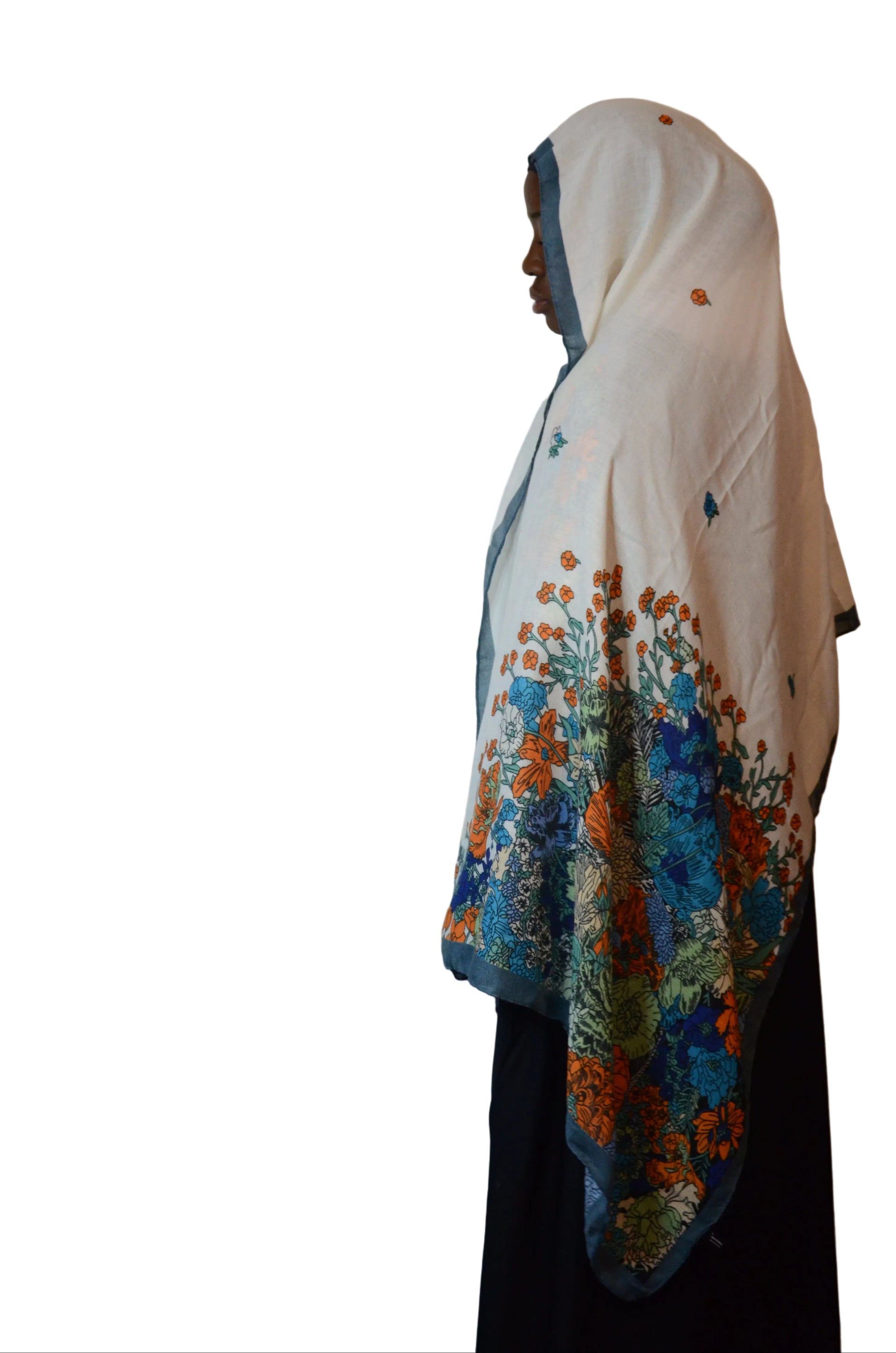 Model wearing an ivory cotton linen hijab with multicolor floral botanical print, shown from the side with soft drape.