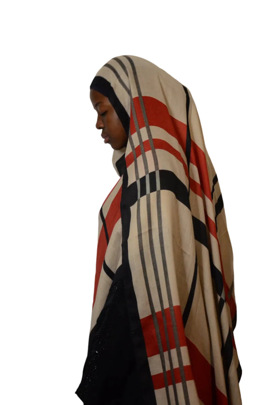 Person wearing a patterned headscarf on a plain background