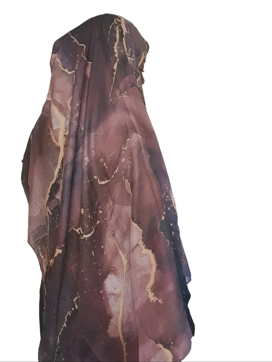 Model wearing a plum marble cotton modal print hijab styled in a loose side drape, showcasing soft fabric flow and blended tones.