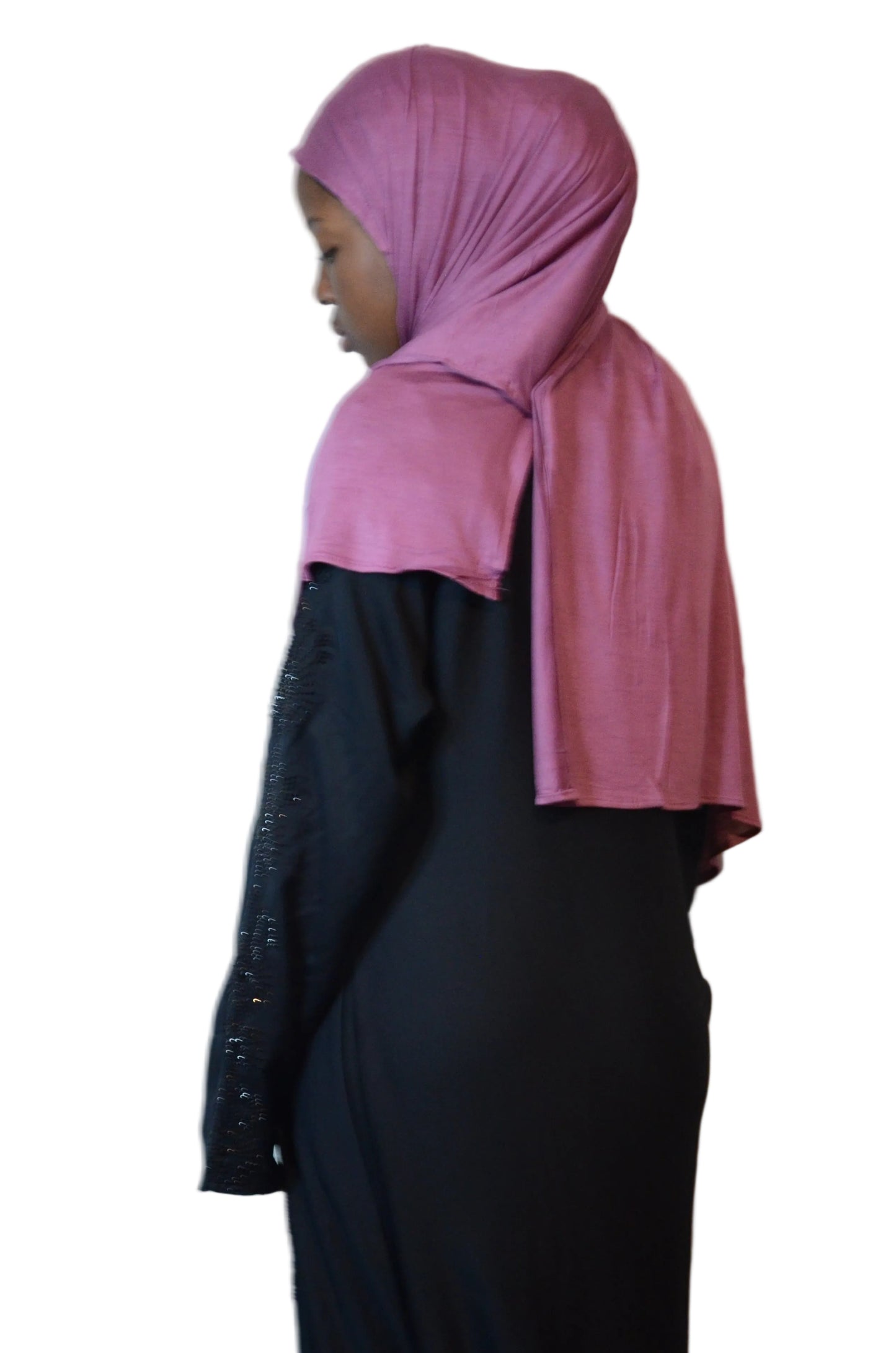 Model wearing a dusty rose plain jersey hijab styled simply, showing smooth stretch fabric and full coverage from the back.