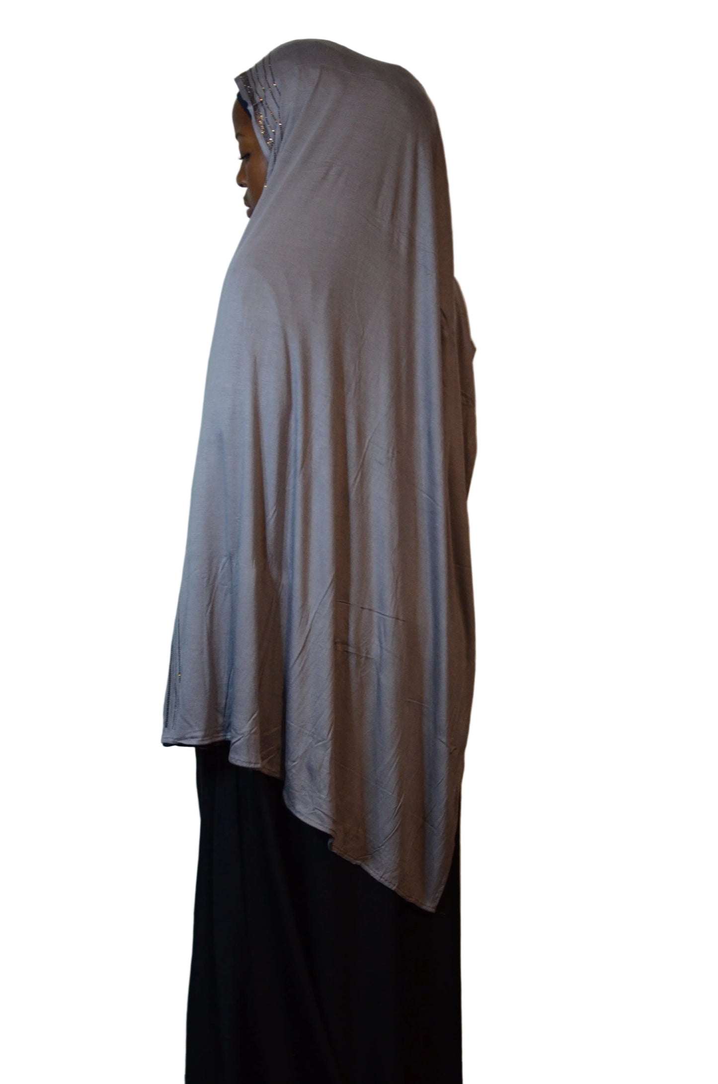 Model wearing a grey premium jersey hijab showing full drape and rhinestone detailing along the edge from a side angle.