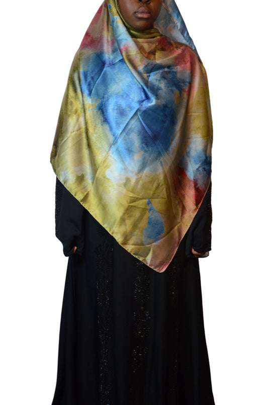 Model wearing a soft satin-feel marble print hijab in earthy multicolour tones, styled in a front drape showcasing blue, olive, and rose hues.