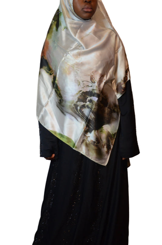 Model wearing a satin-feel marble print hijab with soft ivory, green, and earthy tones, styled over a black abaya.